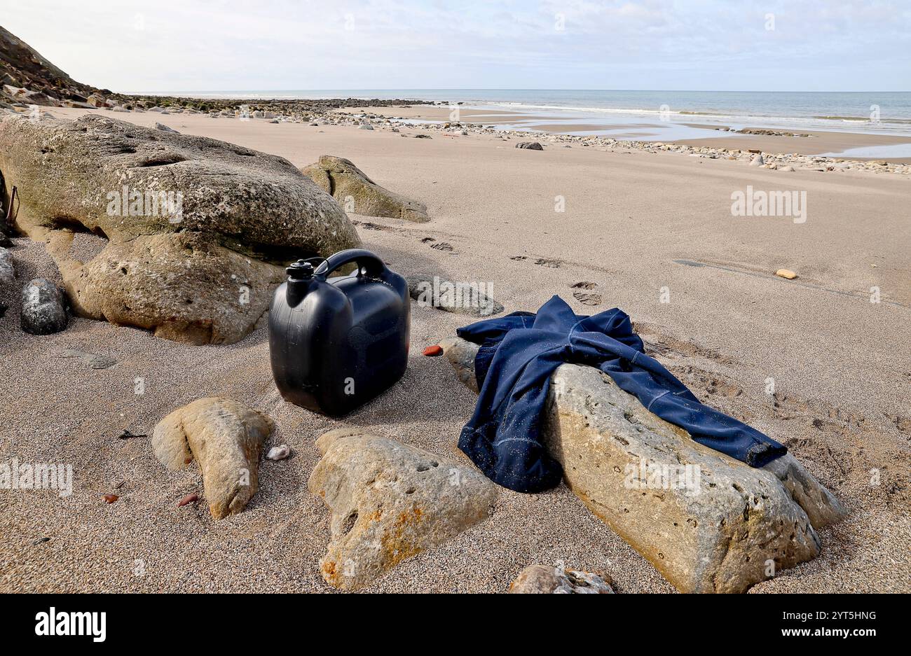 Le Portel (Nord de la France), 15 avril 2024 : bidon d'essence pour un petit bateau et pull appartenant à un migrant abandonné sur une plage entre la Ning Banque D'Images