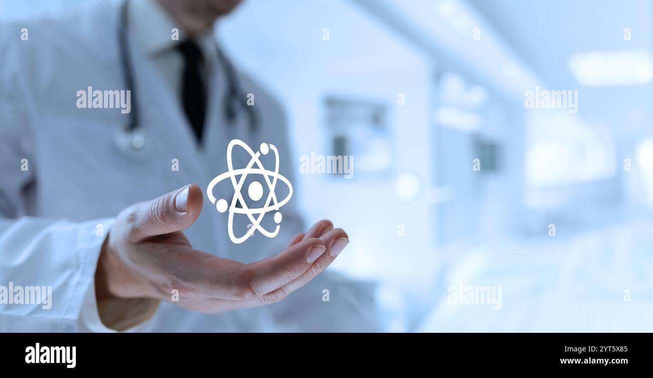 Un médecin ouvre sa paume, dévoilant une icône atomique, représentant les éléments essentiels de la matière et les progrès de la science médicale Banque D'Images