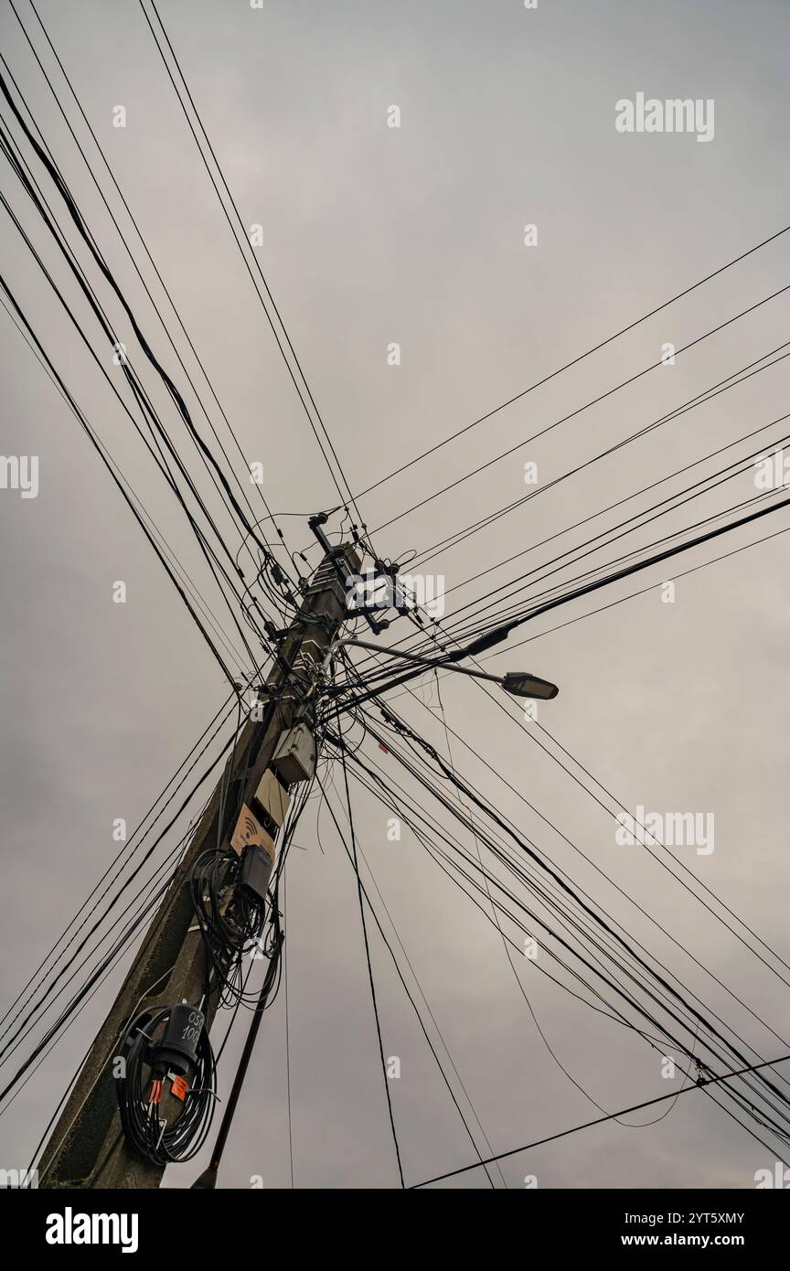 Poteaux électriques avec de nombreux fils par temps nuageux. Banque D'Images