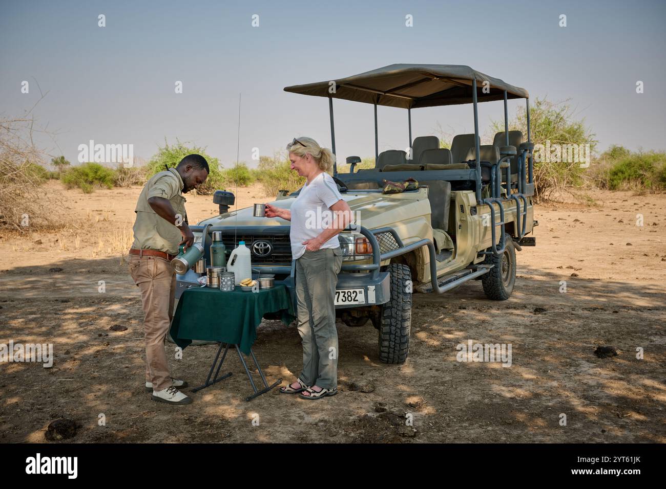Touriste et guide à l'heure du thé sur safari à leur véhicule safari, South Luangwa National Park, Mfuwe, Zambie, Afrique Banque D'Images