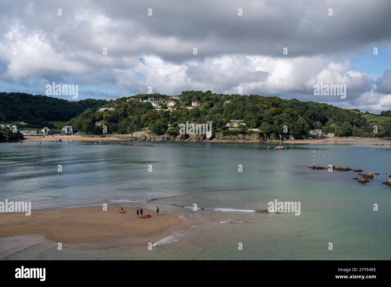 Trois amis sur Salcombe Sand-bar avec leurs canoës de mer, l'eau calme qui les entoure et les sables Nord et Sud en arrière-plan photographiés depuis le sentier côtier Banque D'Images