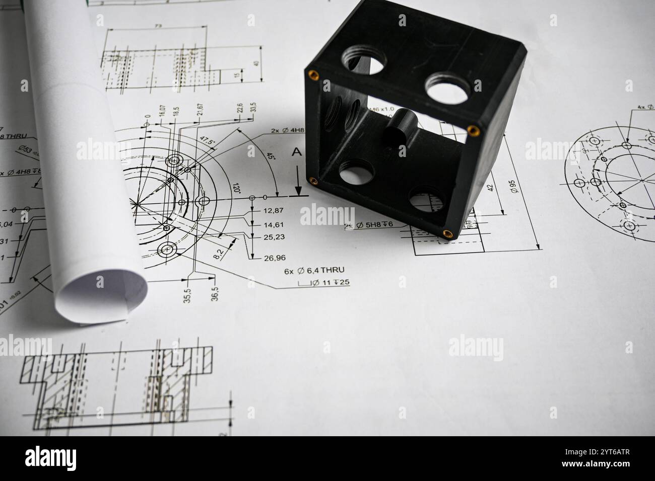 Prototype en plastique noir reposant sur un dessin technique avec des mesures, mettant en valeur la précision et l'ingénierie. Banque D'Images