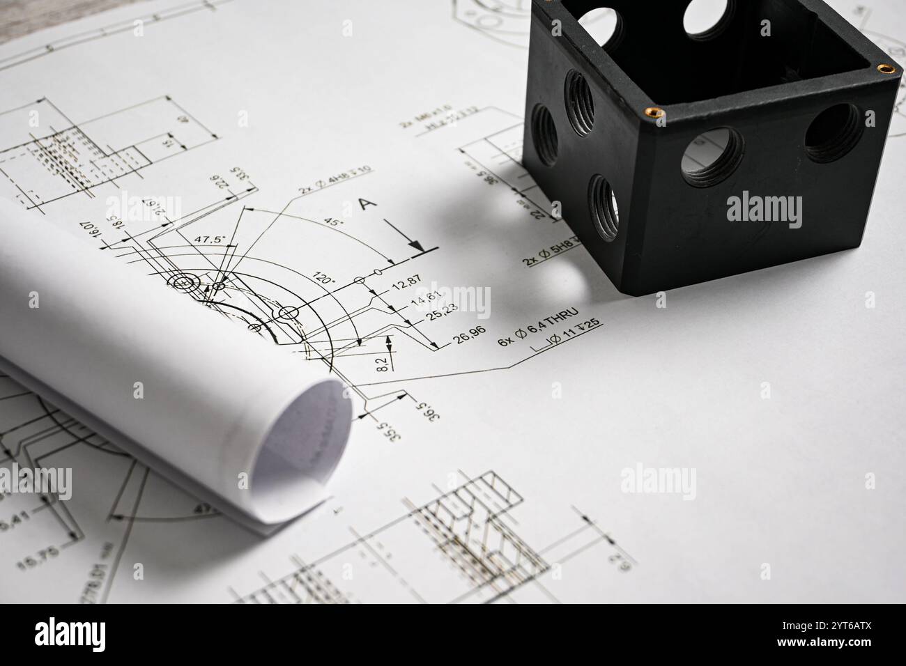 Prototype en plastique noir reposant sur un dessin technique avec des mesures, mettant en valeur la précision et l'ingénierie. Banque D'Images