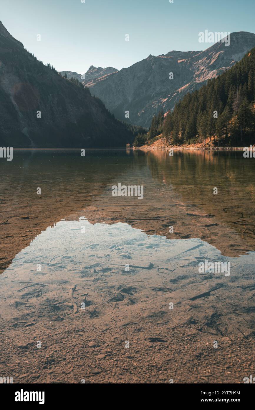 Vue sur le lac de Vilsalpsee, reflétant la forêt environnante et les montagnes des Alpes de Allgäu. Atmosphère automnale à cette destination d'excursion populaire avec un ciel bleu et une vue dégagée jusqu'au fond du lac. Banque D'Images