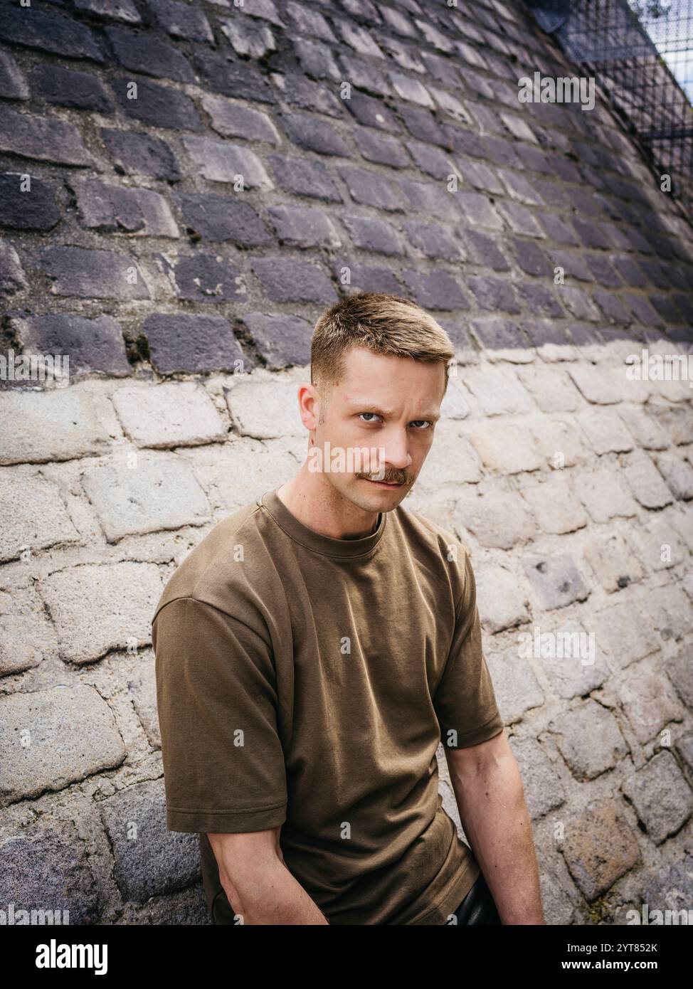 Homme appuyé contre un mur dans la ville Banque D'Images