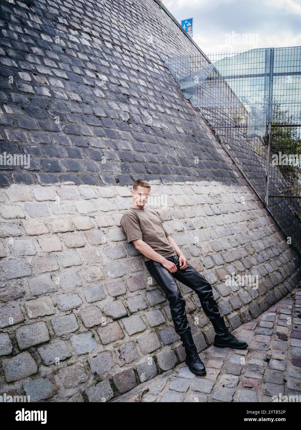 Homme appuyé contre un mur dans la ville Banque D'Images