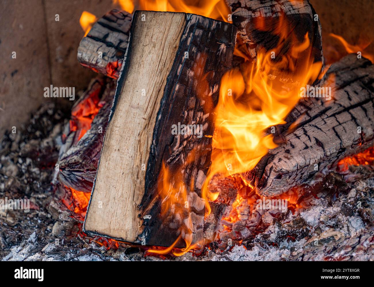 Gros plan d'un feu en feu avec une poêle à bois, des flammes et des cendres Banque D'Images