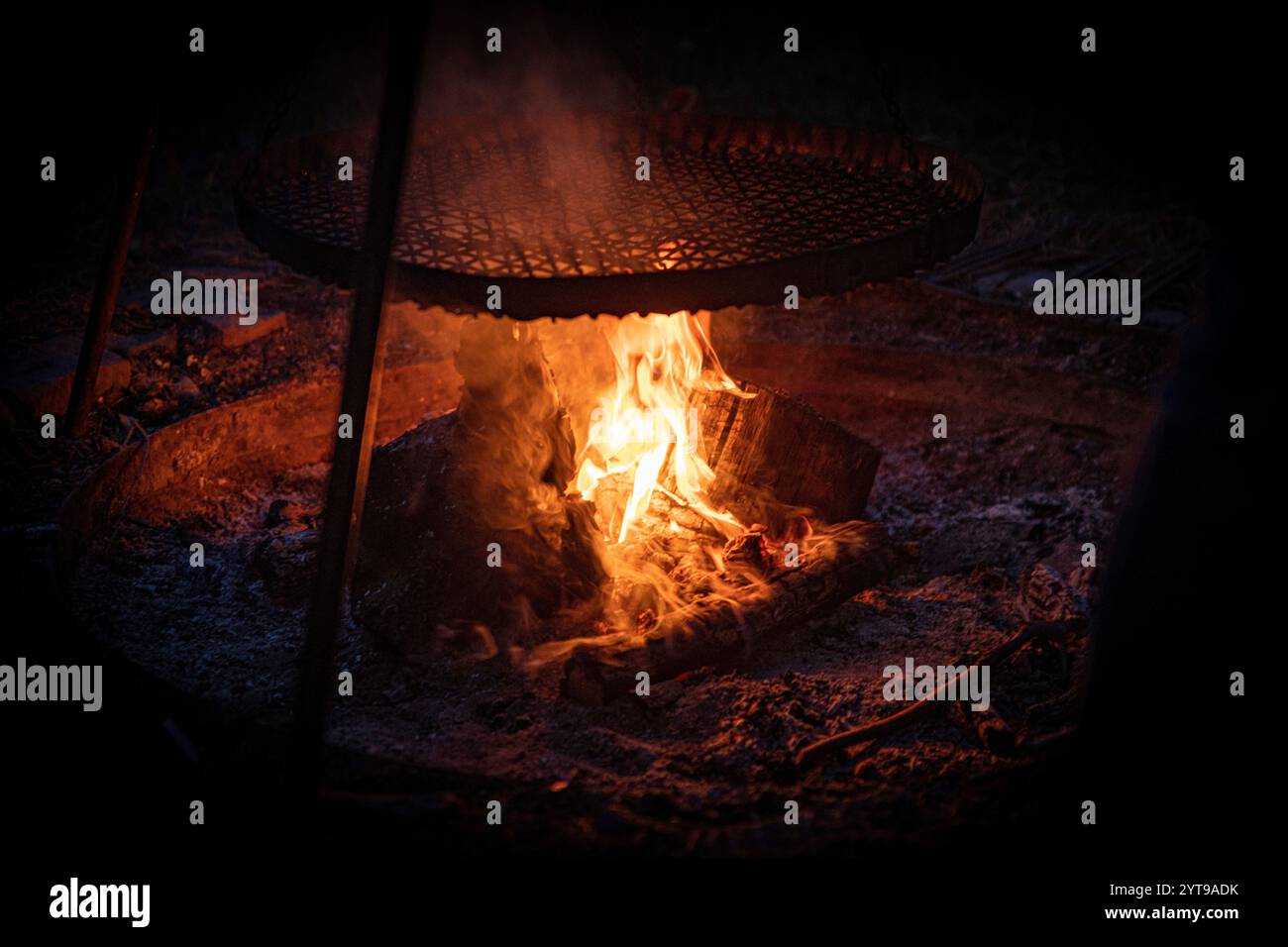 Feu brûlant brillamment avec des braises sur un fond noir Banque D'Images