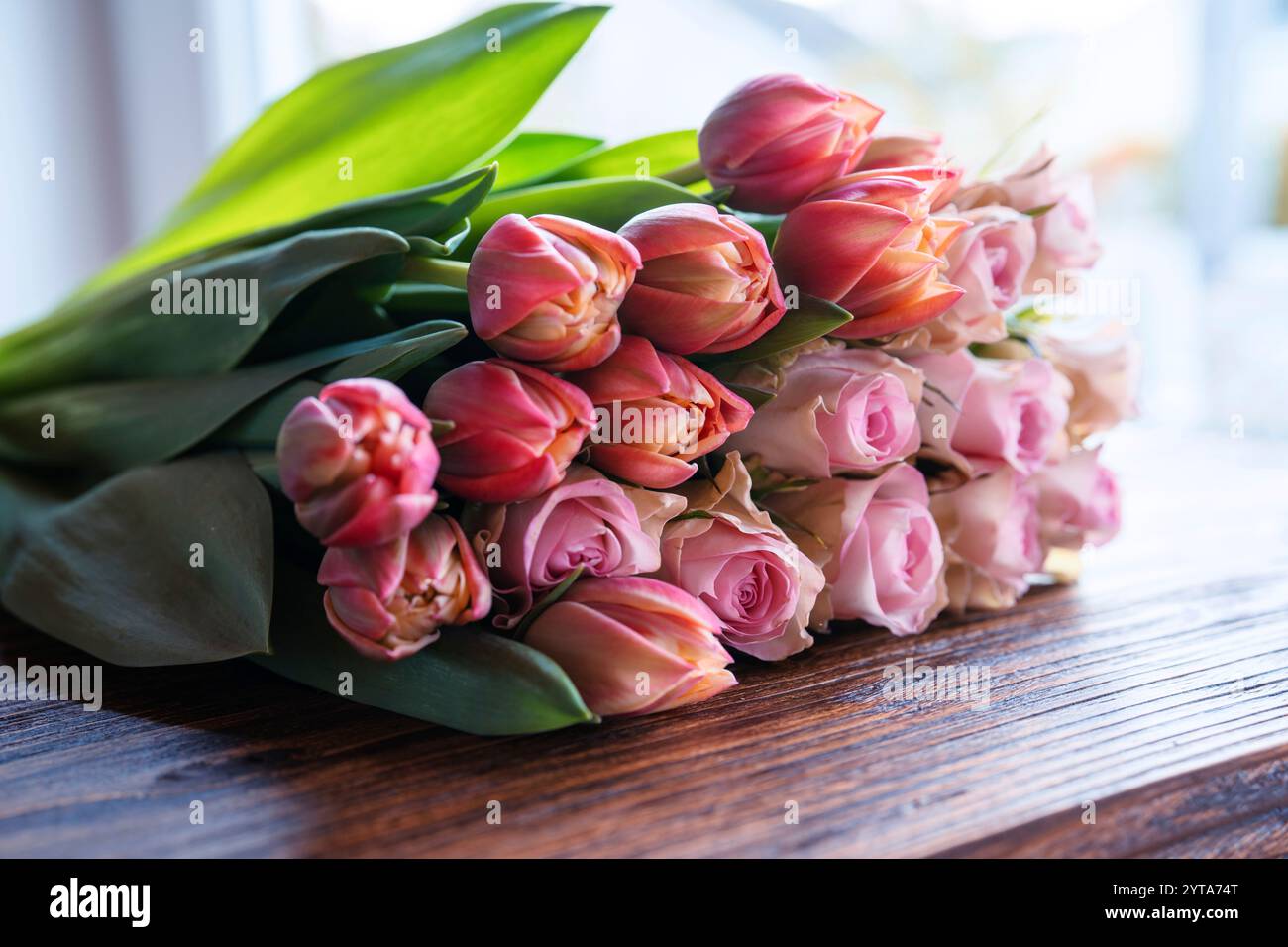 Bouquet de belles roses et tulipes roses sur bois sombre. Fond de concept pour la fête des mères, la saint-valentin et les mariages. Banque D'Images
