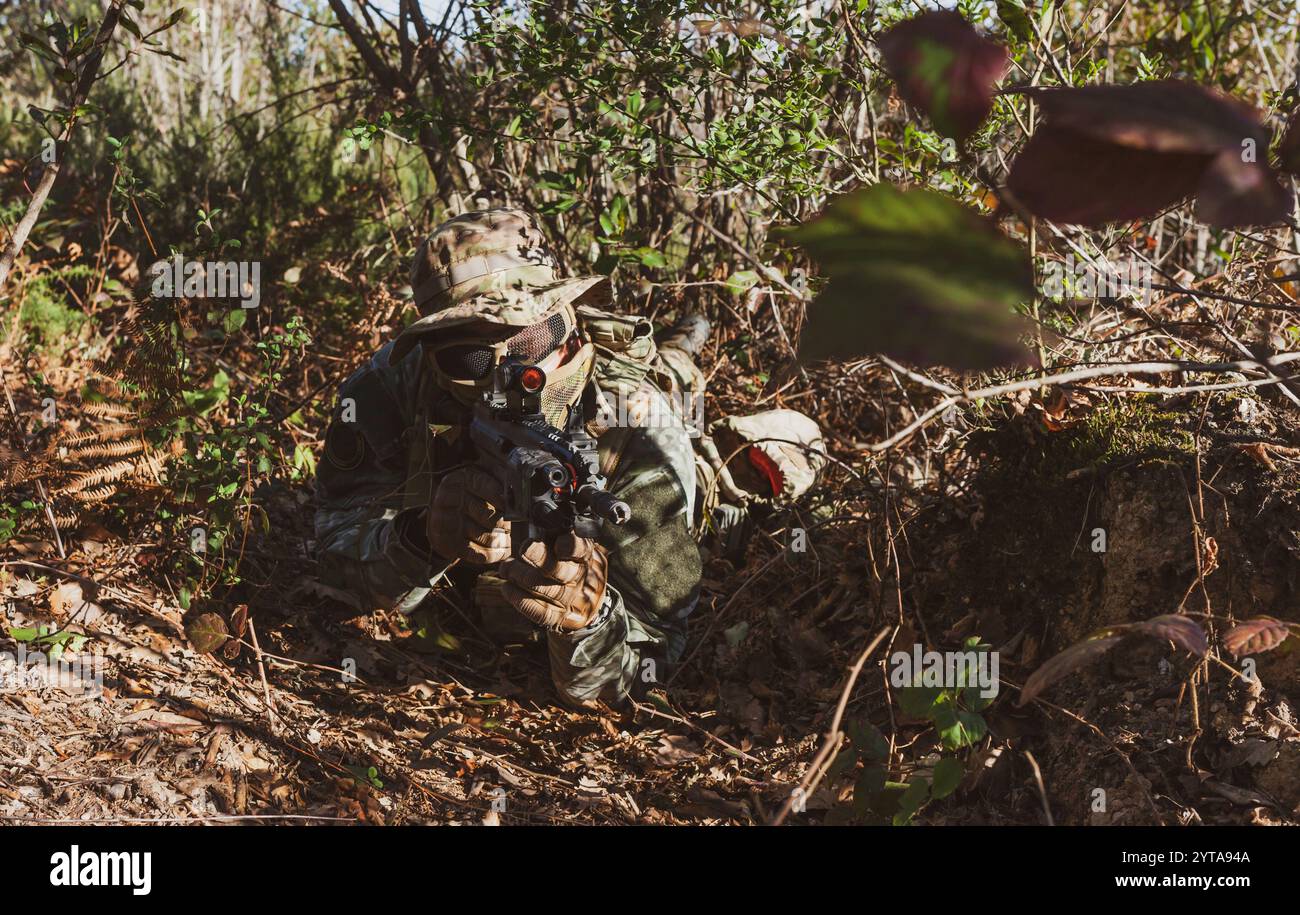 Joueur de jeu militaire Airsoft en uniforme de camouflage avec fusil d'assaut armé Banque D'Images