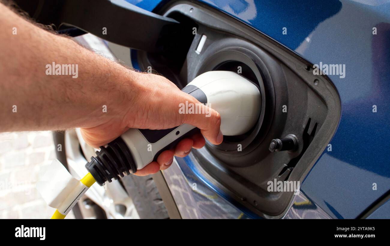 Le chargeur de voiture électrique branché à la socketLa voiture électrique moderne charge la batterie Banque D'Images