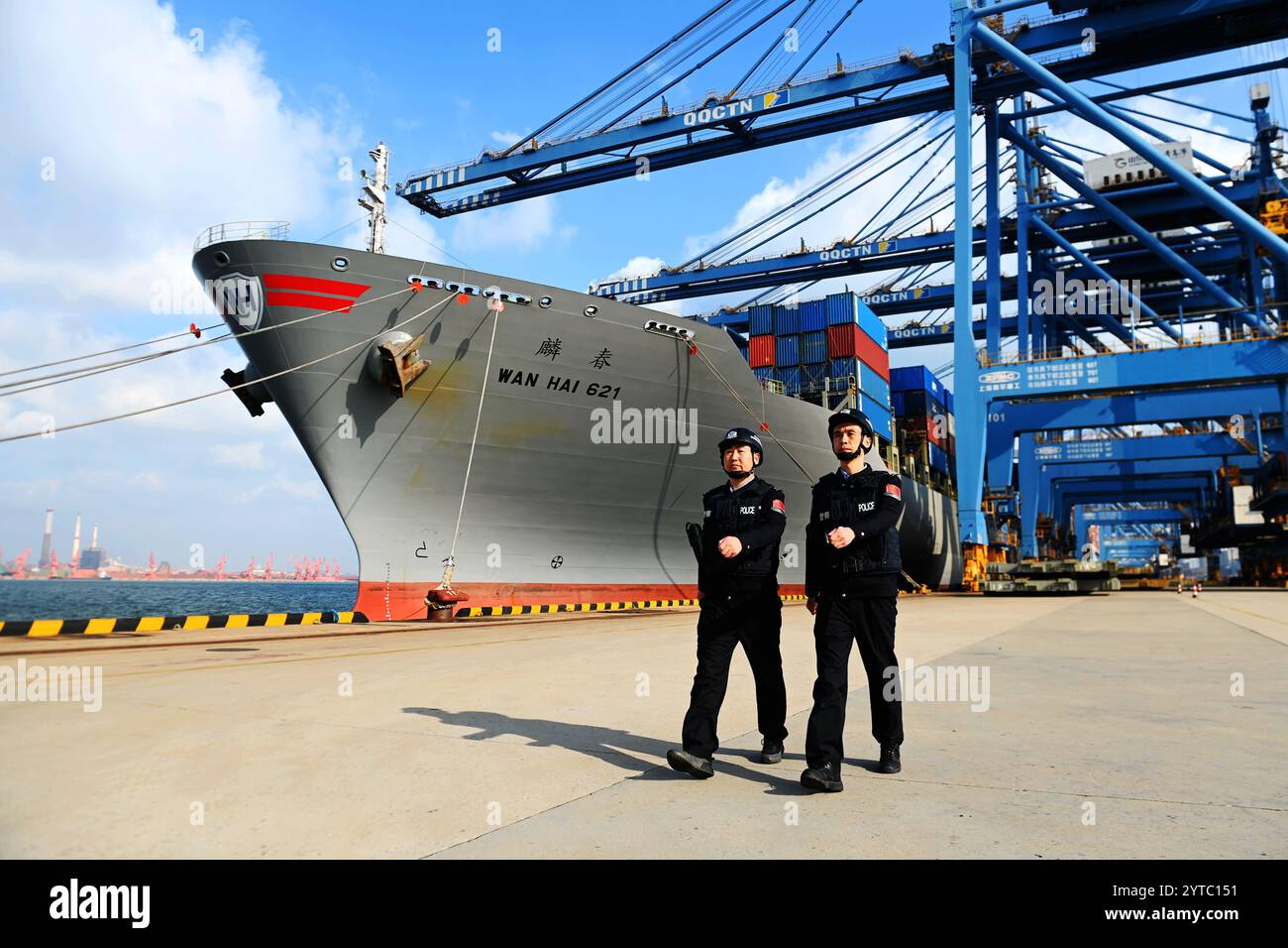QINGDAO, CHINE - 7 DÉCEMBRE 2024 - des policiers du poste d'inspection frontalier de Huangdao patrouillent sur le côté d'un cargo au terminal d'automatisation Banque D'Images