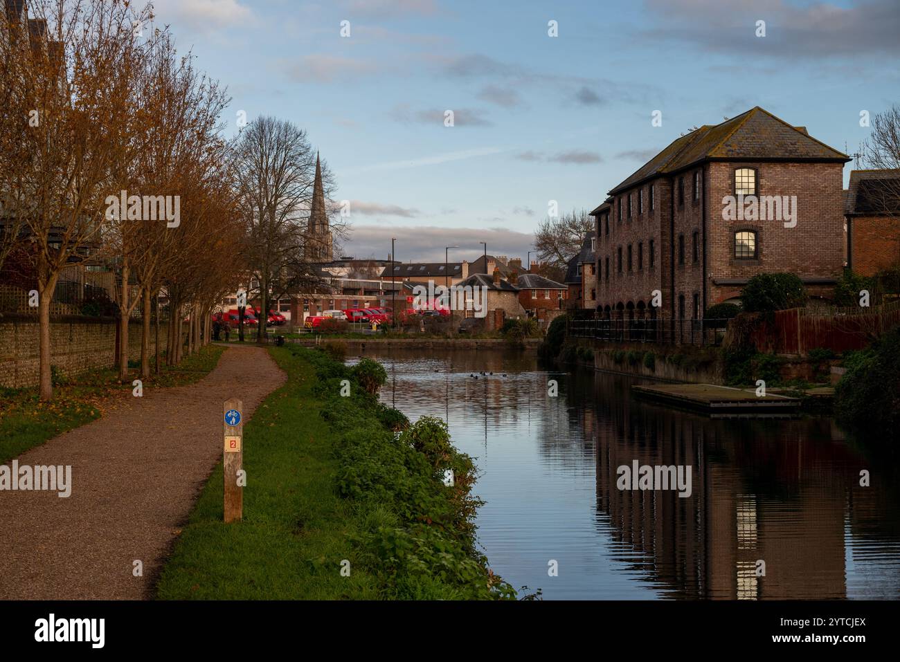 Canal de Chichester avec la tour de la cathédrale au loin ainsi que le bureau postal Royal avec ses véhicules rouge vif. Décembre 2024. Banque D'Images