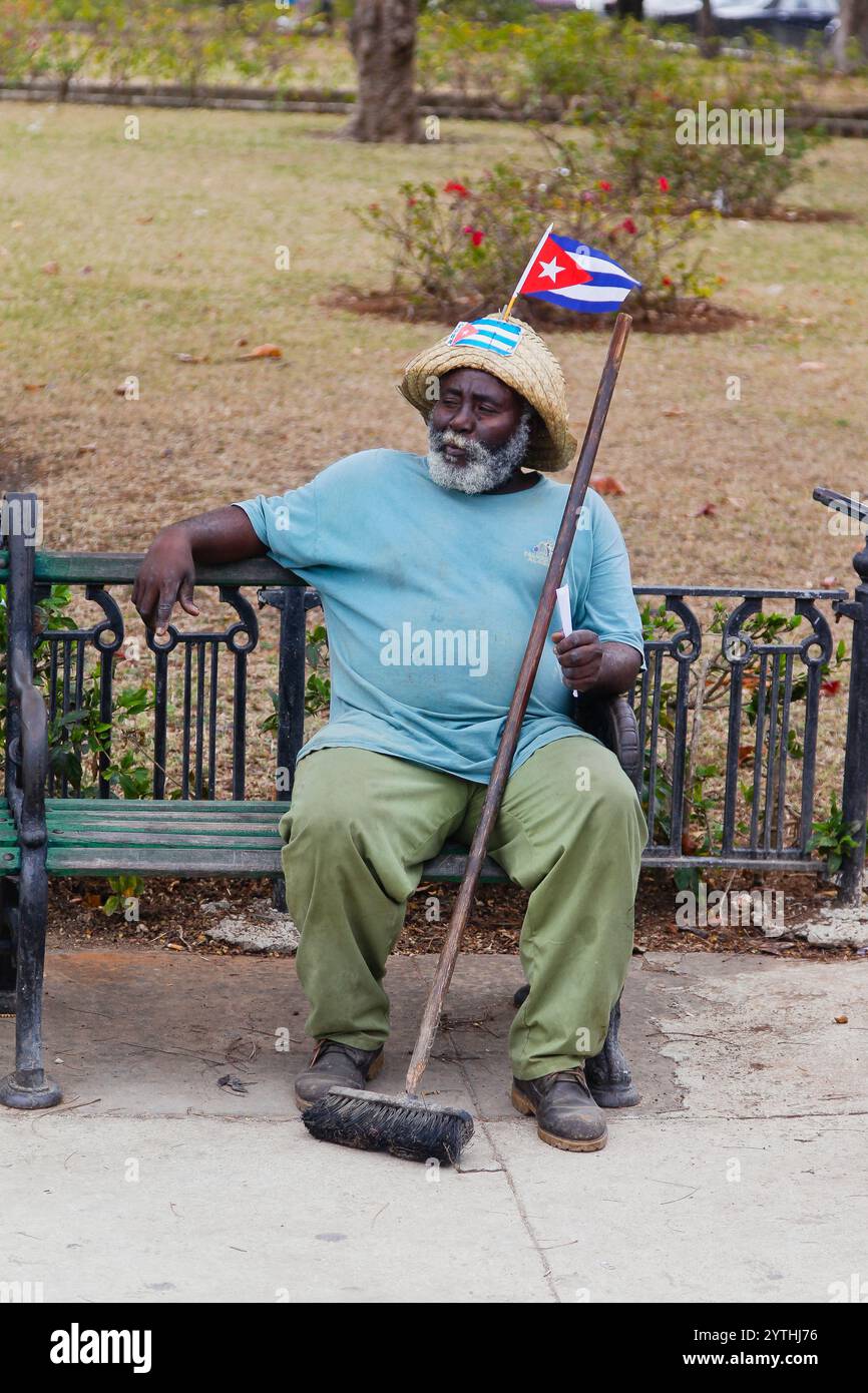 Un travailleur de l'assainissement de la ville prend un repos et mange des arachides, la Havane, Cuba Banque D'Images
