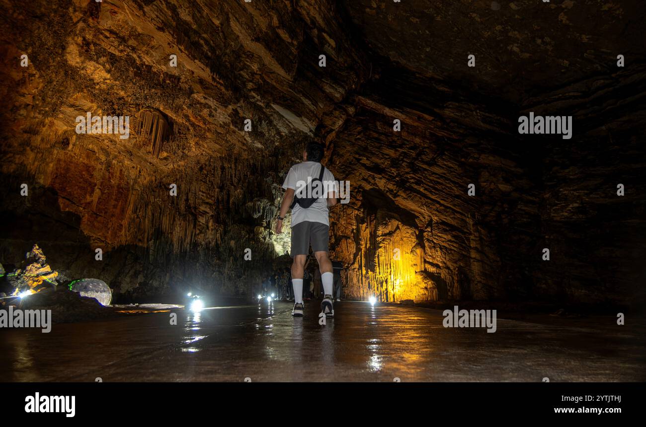 Un visiteur se promène dans les magnifiques grottes du Parque Nacional Grutas de Cacahuamilpa, entourées d'impressionnantes formations rocheuses et de sentiers faiblement éclairés. Banque D'Images