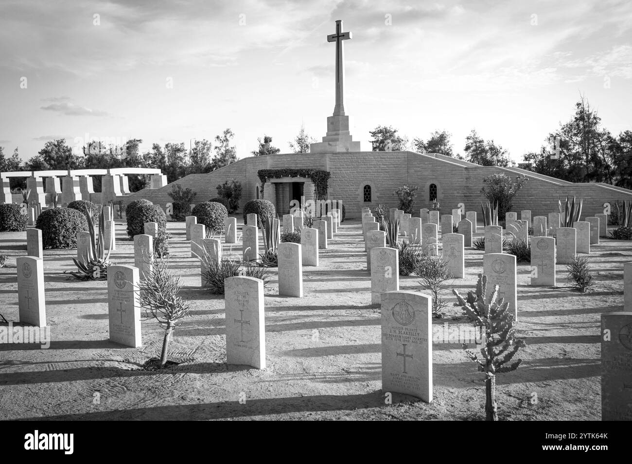 Le cimetière de guerre d'El Alamein en Égypte honore les soldats de la seconde Guerre mondiale avec des rangées de tombes militaires, la Croix du sacrifice et un désert tranquille en toile de fond. Banque D'Images