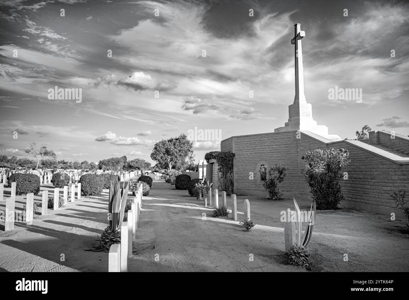 Le cimetière de guerre d'El Alamein en Égypte honore les soldats de la seconde Guerre mondiale avec des rangées de tombes militaires, la Croix du sacrifice et un désert tranquille en toile de fond. Banque D'Images