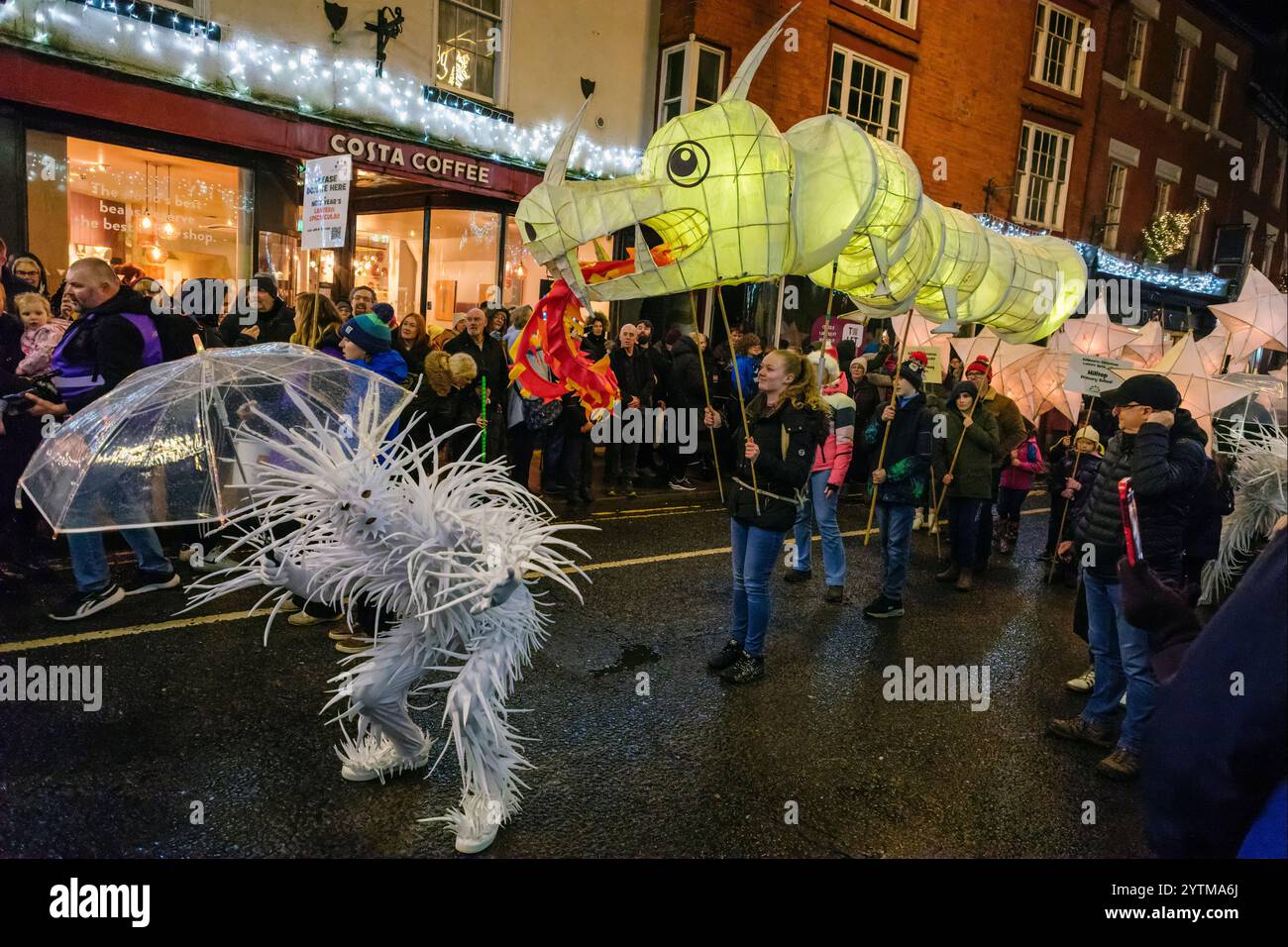 Une lanterne élaborée en forme de dragon et une danseuse dans la parade des lanternes de Noël, Ashbourne, Derbyshire Banque D'Images