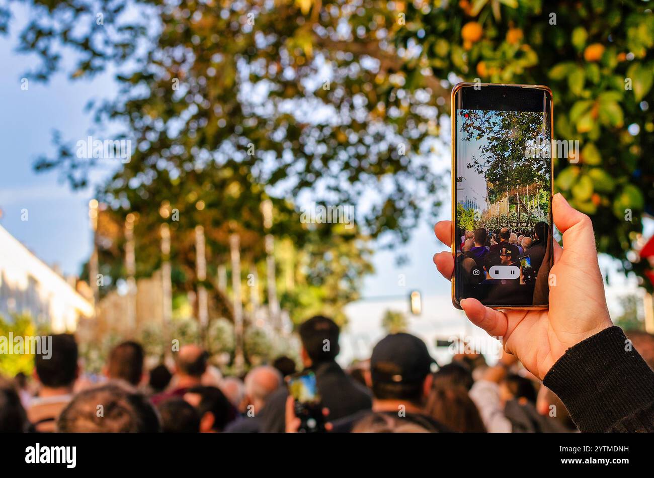 Séville, Espagne ; 7 décembre 2024 : main d'une femme caucasienne enregistrant la procession de notre-Dame de l'espérance de Triana pendant la Magna. Banque D'Images