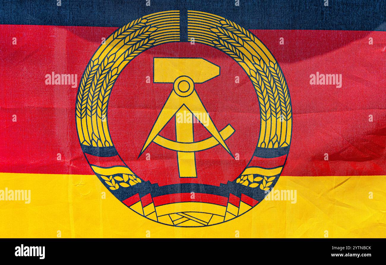 Hüntwangen, Suisse, 24 août 2024 : le drapeau de la République démocratique allemande avec un marteau, une boussole et une couronne de blé en noir, rouge et or. Banque D'Images