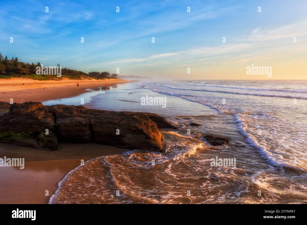 Belle plage de grottes de sable sur la côte Pacifique de l'Australie au lever du soleil. Banque D'Images