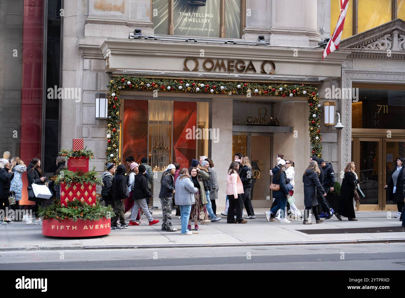 Les gens marchant le long de la 5ème Avenue ont passé le magasin Omnega le Black Friday, le début officiel de la saison des achats de vacances à New York. Banque D'Images