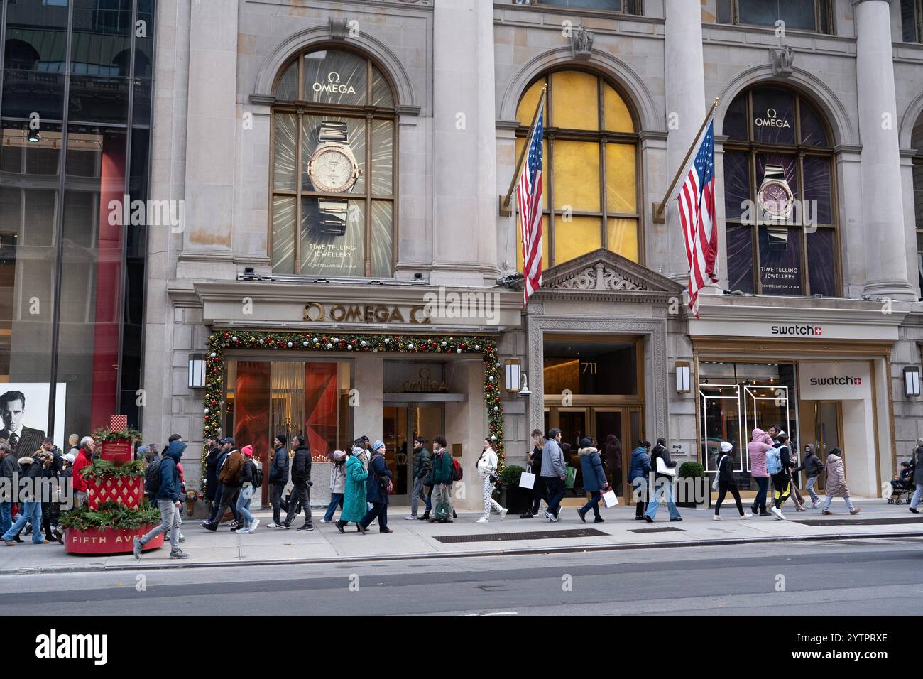 Les gens marchant le long de la 5ème Avenue ont passé le magasin Omnega le Black Friday, le début officiel de la saison des achats de vacances à New York. Banque D'Images
