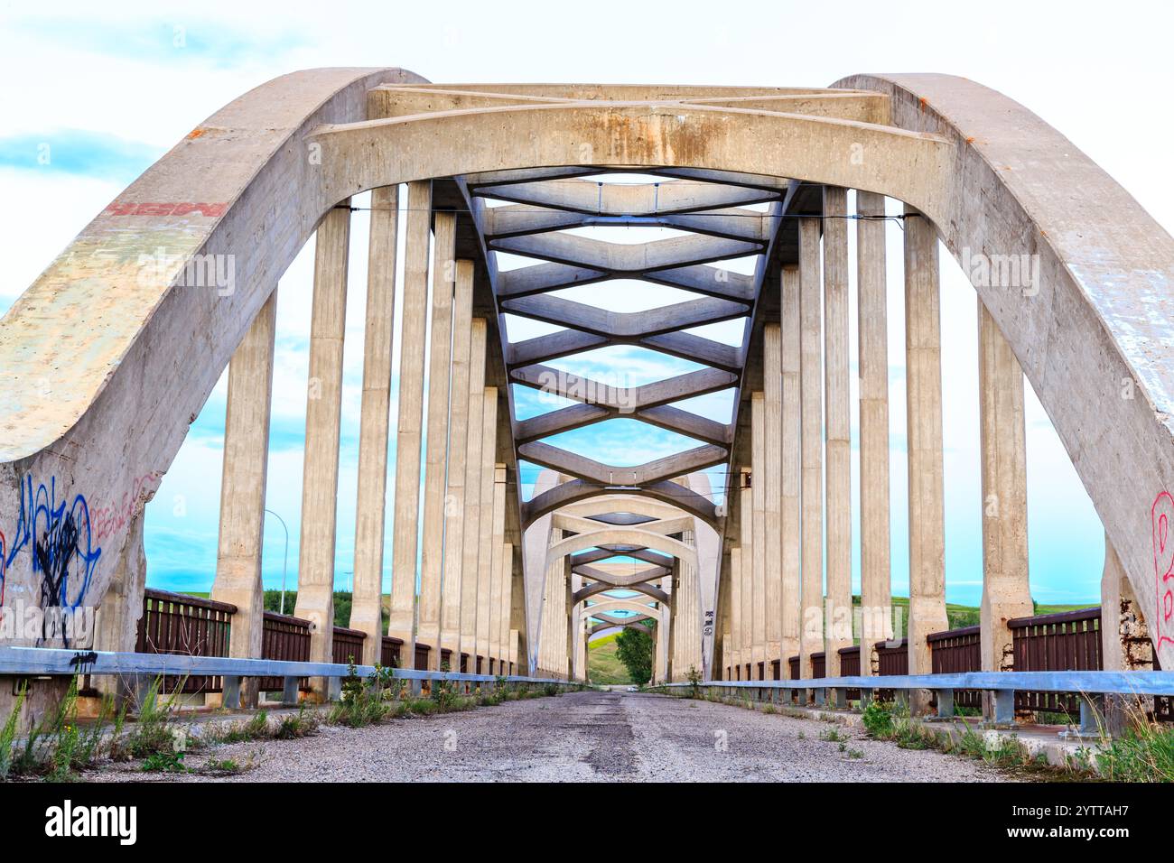 Un pont avec des graffitis dessus et un ciel bleu clair en arrière-plan. Le pont est long et a beaucoup d'espace vide Banque D'Images