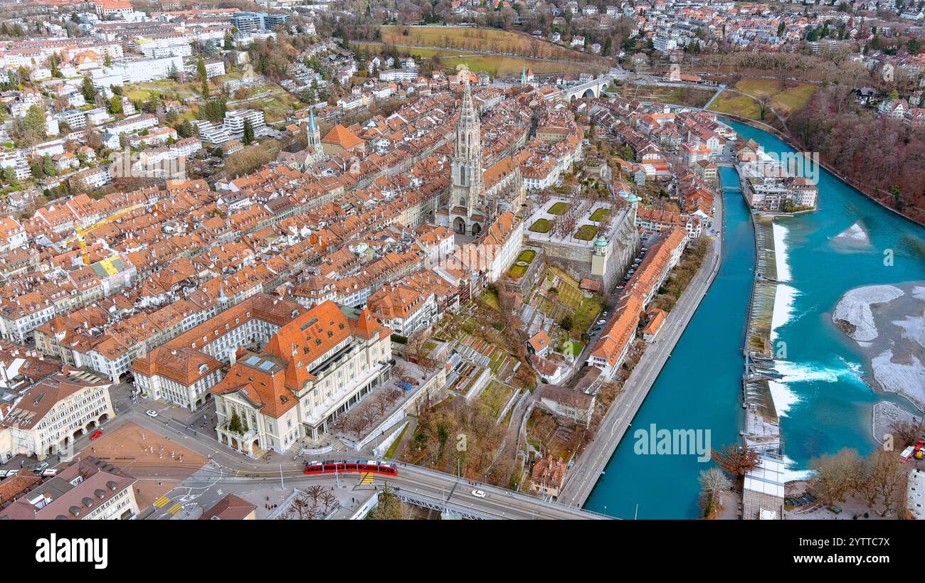 Image aérienne à couper le souffle de la vieille ville de Berne avec la cathédrale historique de Münster, des maisons aux toits rouges et la paisible rivière Aar. Banque D'Images
