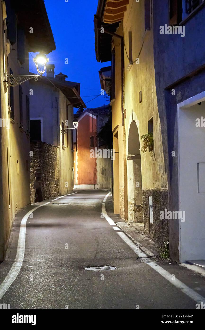 Rue étroite et bâtiments en pierre à San Felice del Benaco la nuit, Italie Banque D'Images