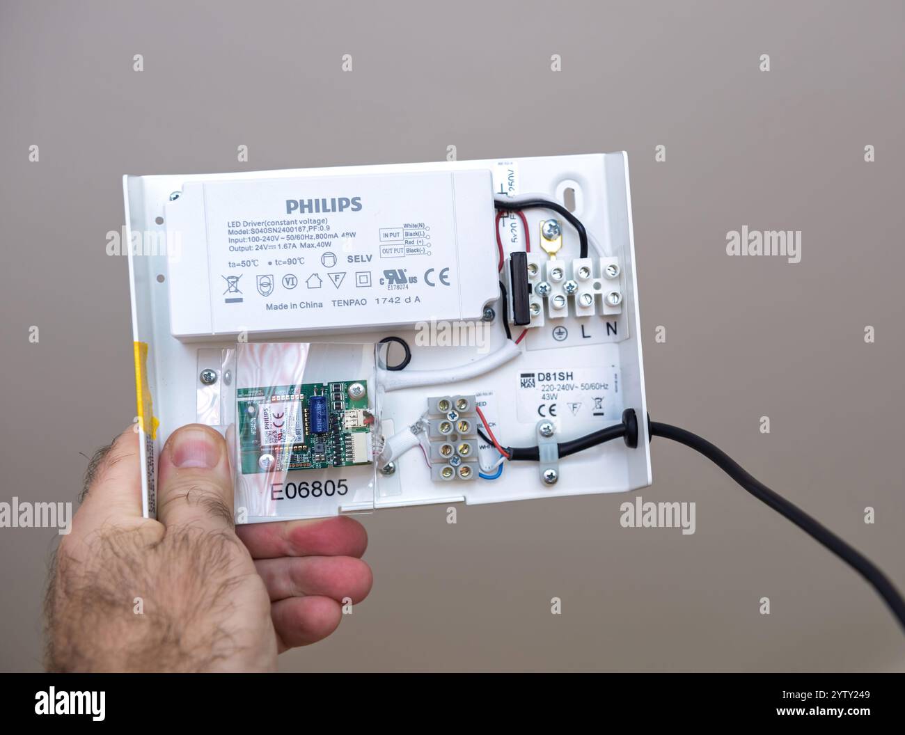Paris, France - Nov 17, 2021 : une main tenant un module de driver de LED Philips avec des composants internes visibles, y compris un driver Luceplan D81SH, le câblage, la carte de circuit imprimé et les bornes de connexion 0 Hue Engine V1.0 Banque D'Images