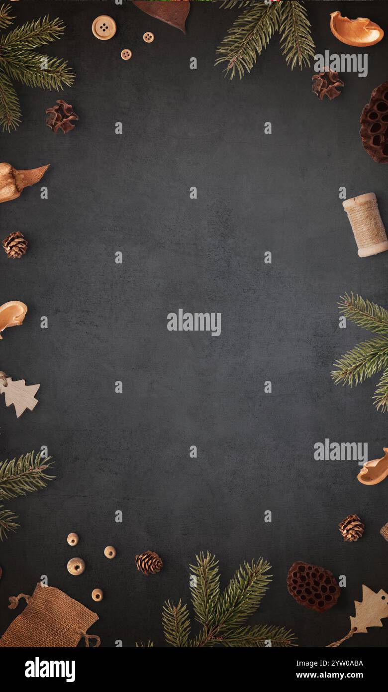 Table noire entourée de branches d'arbre de Noël et de décorations de vacances traditionnelles, avec un espace vide central pour le texte promotionnel dans un festi Banque D'Images