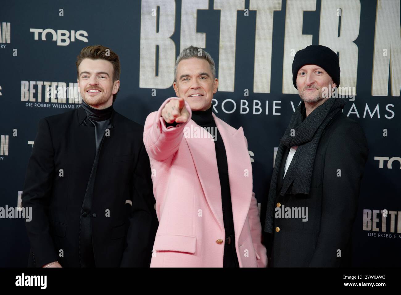 Cologne, Allemagne. 08 décembre 2024. L'acteur Jonno Davies (gauche-droite), le chanteur Robbie Williams et le réalisateur Michael Gracey assistent à la première du film "Better Man - The Robbie Williams Story". Crédit : Henning Kaiser/dpa/Alamy Live News Banque D'Images