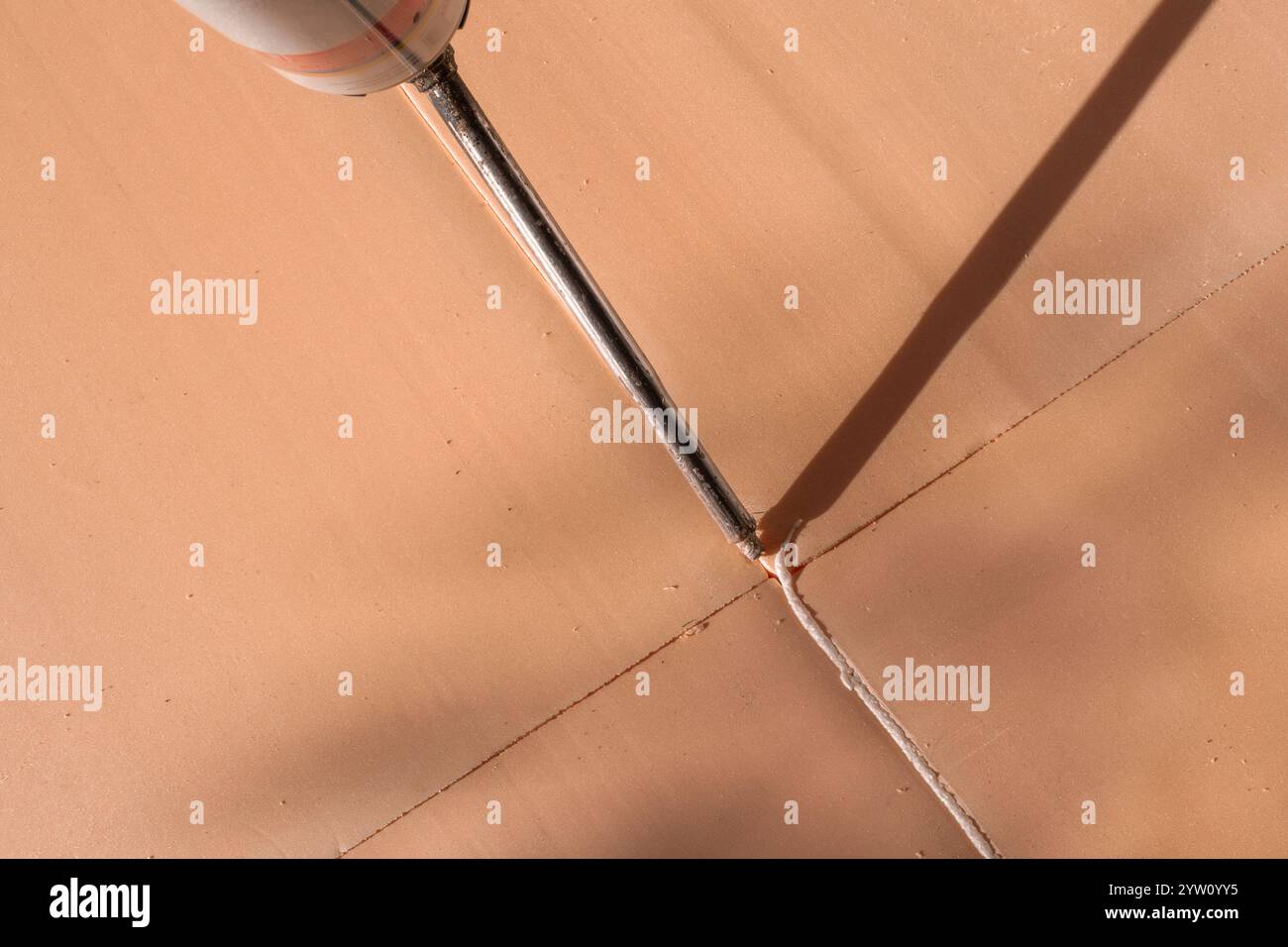 Utilisation de mousse de construction pour sceller les coutures avec un tube. Pose de mousse de polyuréthane sur le sol. Banque D'Images