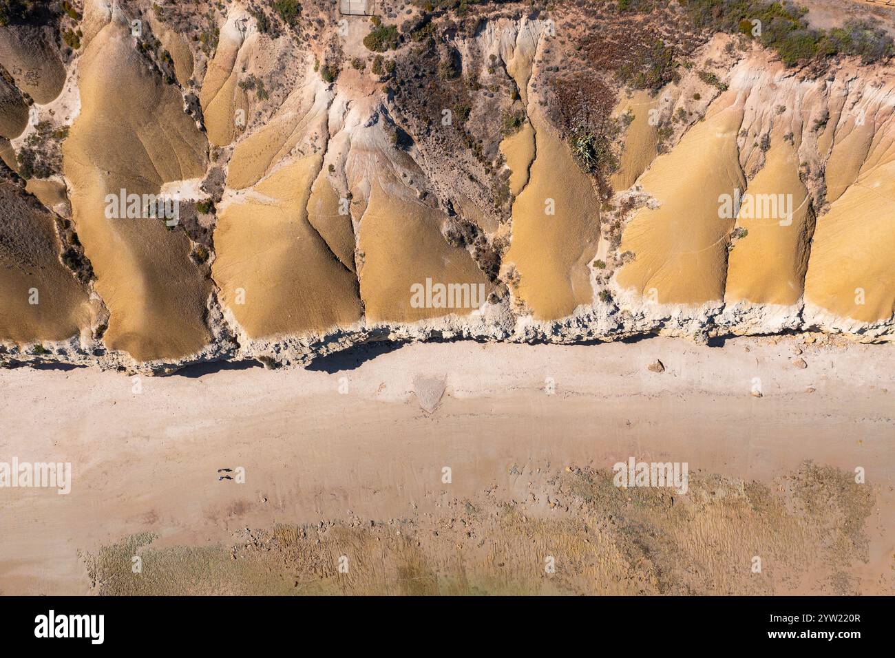 Vue aérienne des falaises côtières érodées descendant jusqu'à une plage de sable à Port Willunga à Adélaïde, Australie méridionale. Banque D'Images