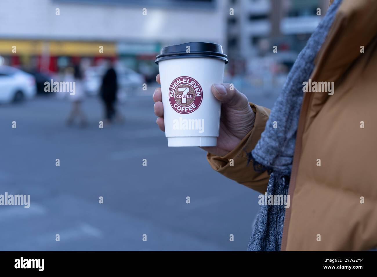 Main tenant une tasse de café Seven-Eleven Banque D'Images