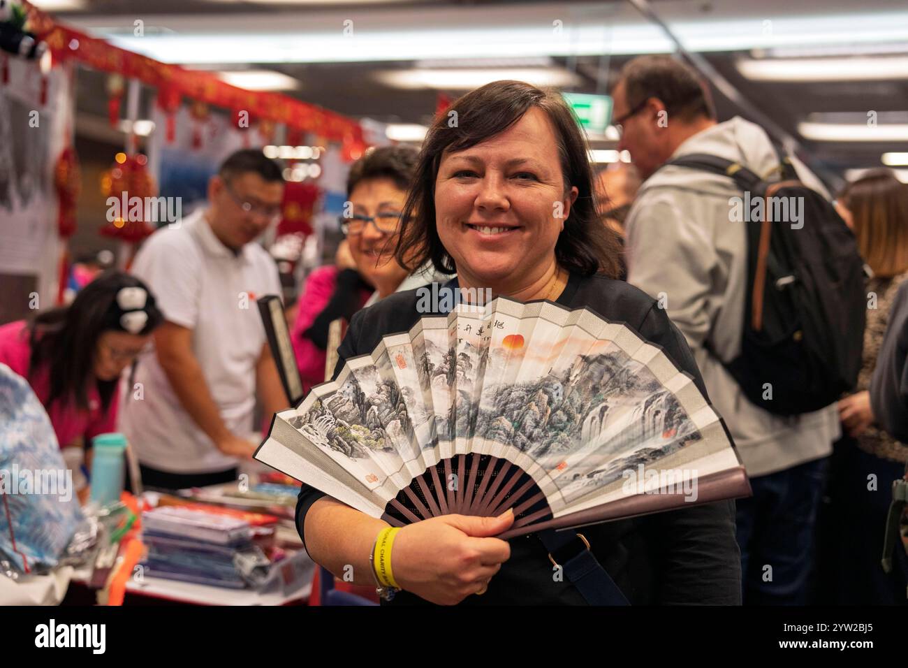Varsovie, Pologne. 8 décembre 2024. Une femme achète un ventilateur au stand chinois lors du 17ème Bazar international de bienfaisance à Varsovie, Pologne, 8 décembre 2024. Plus de 50 ambassades en Pologne se sont jointes à l'événement, les recettes des ventes ayant été reversées à 16 organisations caritatives polonaises. Crédit : Xia Yuanyi/Xinhua/Alamy Live News Banque D'Images