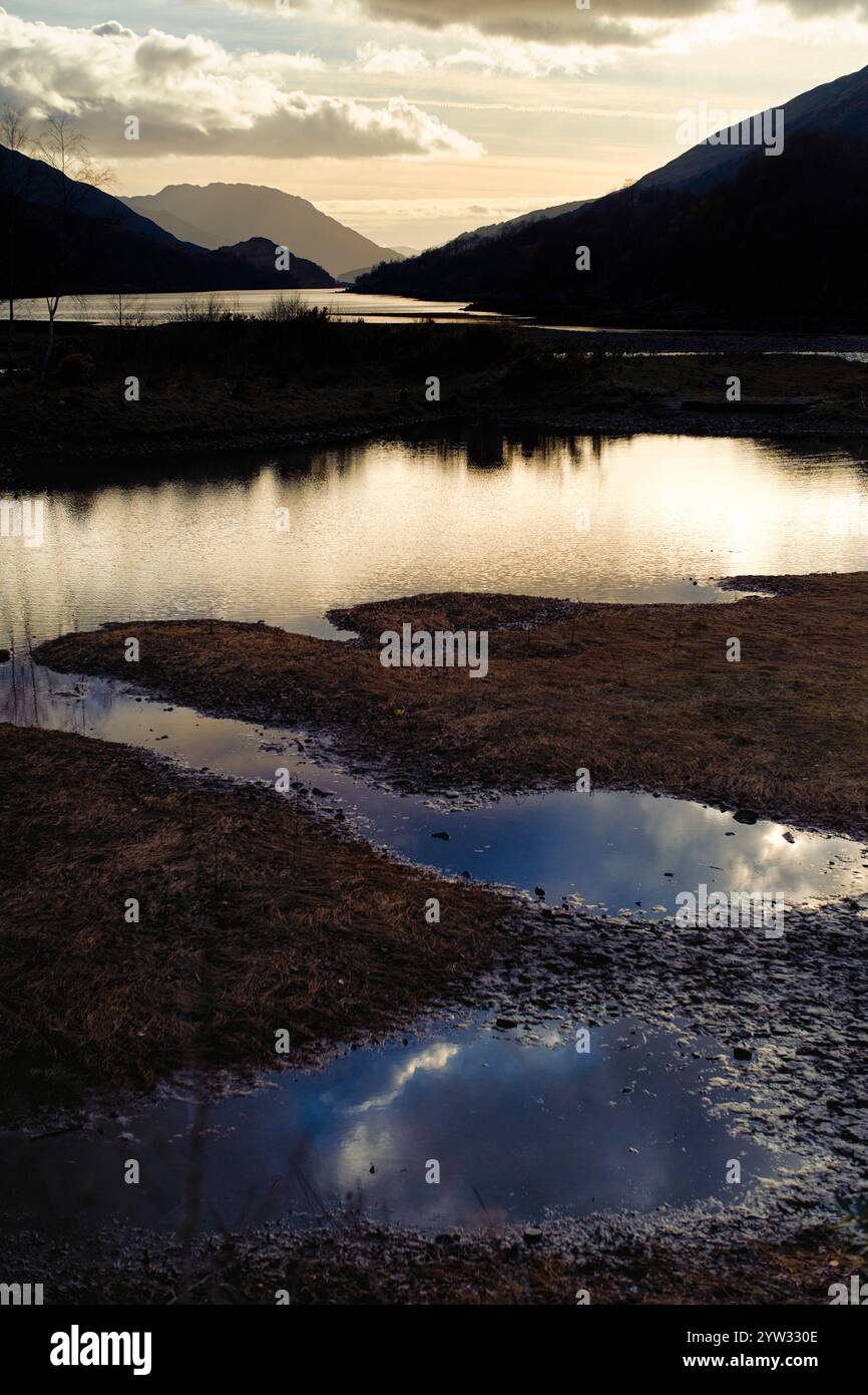 Coucher de soleil sur un paysage de montagne serein avec des reflets dans un plan d'eau, Highlands, Écosse Banque D'Images
