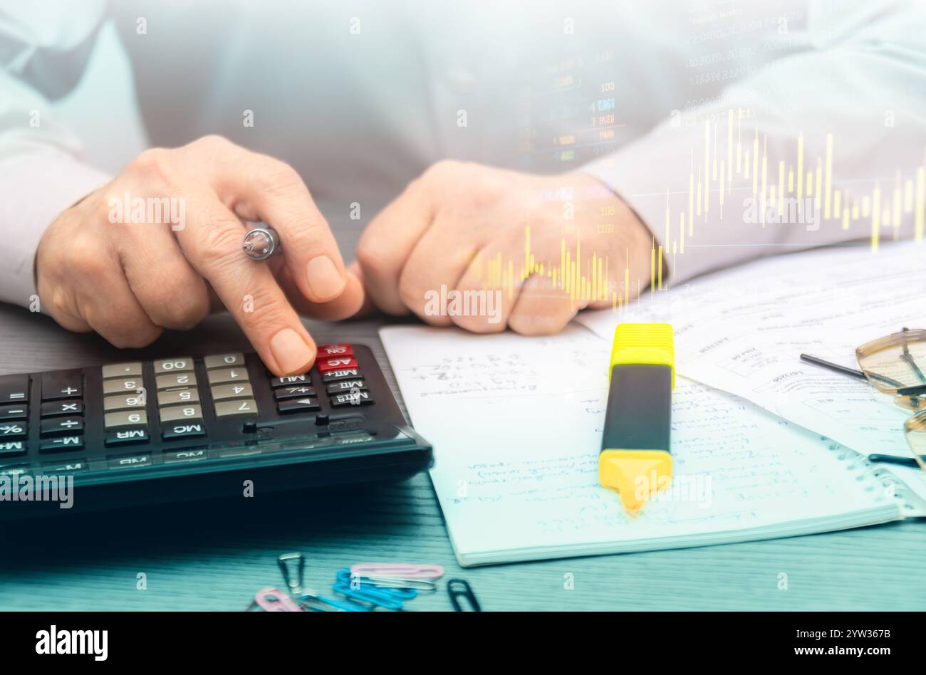 Calculer les dépenses et analyser les données financières dans un espace de travail professionnel avec notes et papeterie à proximité pour référence. Banque D'Images