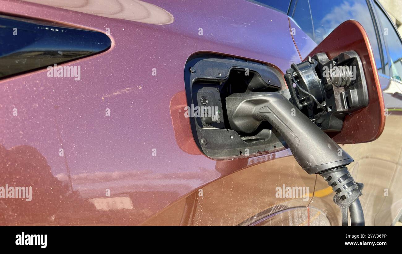 Une voiture électrique en cours de charge à une centrale électrique extérieure, gros plan de la fiche et de la prise. Banque D'Images