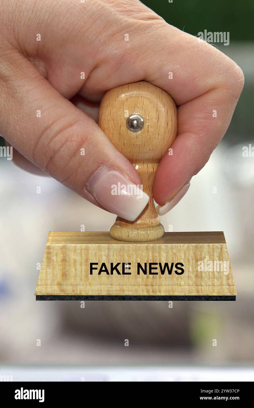 Main avec timbre, main de femme, inscription : Fake News, False, False, rapports, faux rapports, faux Studio, basse-Saxe, République fédérale d'Allemagne Banque D'Images