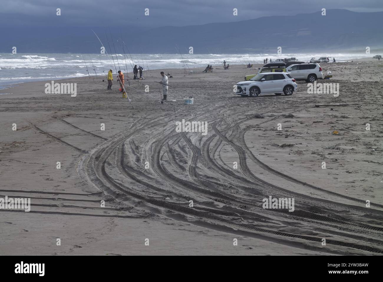 Pêcheurs sur la plage avec des voitures, des traces de pneus dans le sable, Hokkaido, Japon, Asie Banque D'Images