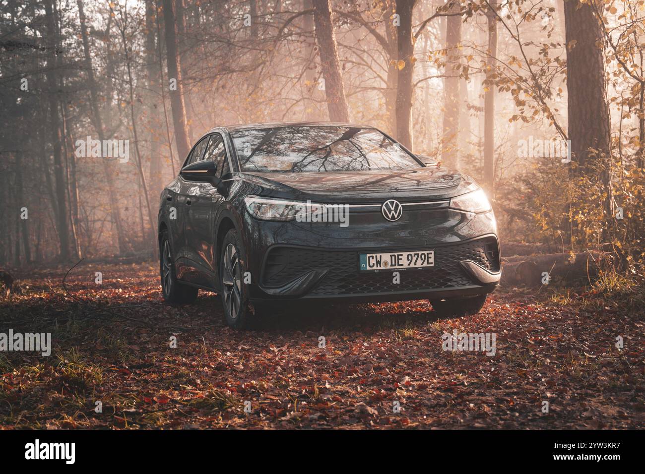 Une Volkswagen est situé dans une forêt brumeuse automnale et est éclairé par la lumière du soir, voiture électrique VW ID5, Deer Carsharing, Gechingen, Black Fo Banque D'Images