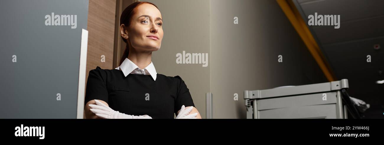 Jeune femme avec calme se tient en toute confiance dans un cadre contemporain avec un éclairage doux. Banque D'Images