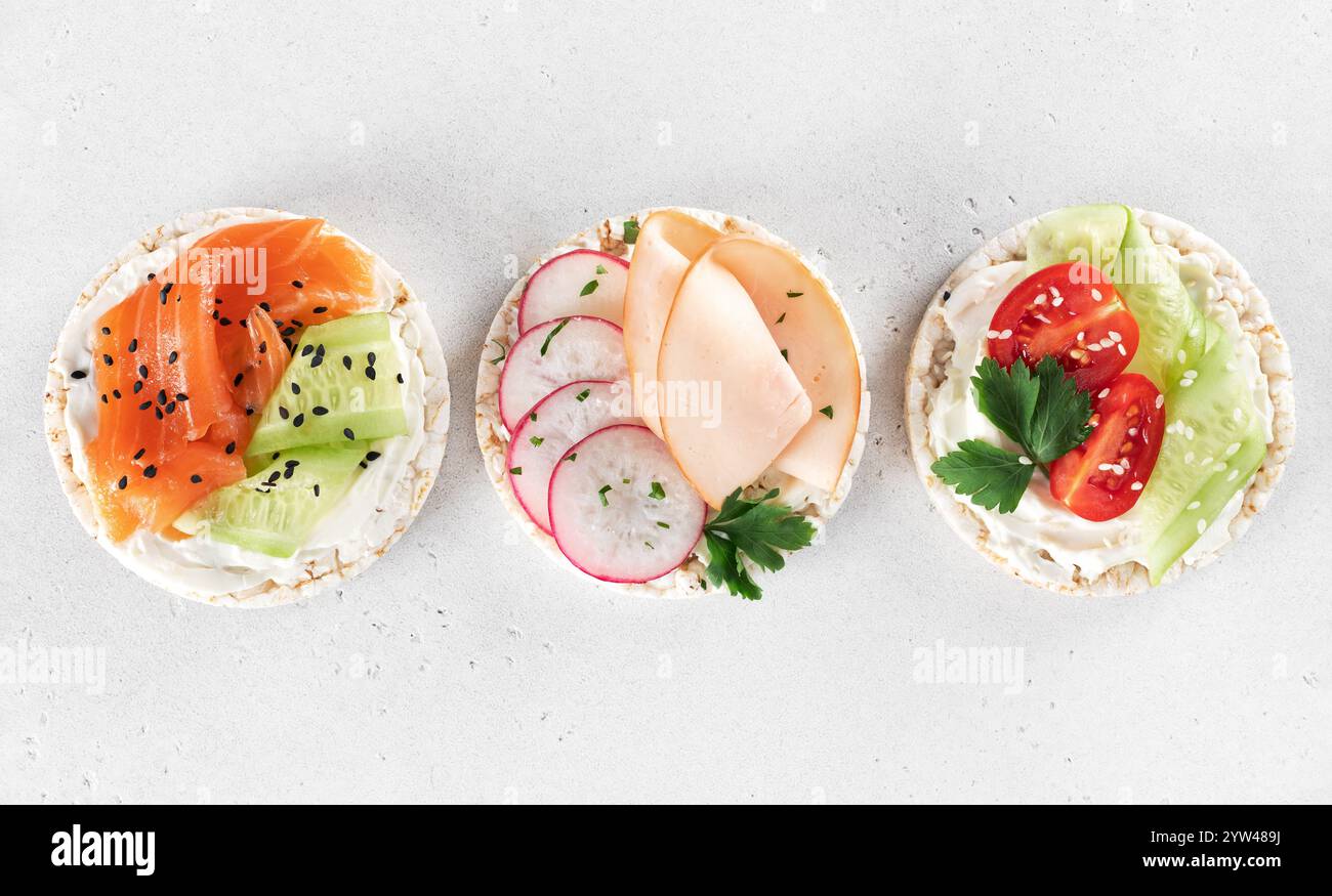 Assortiment gâteau de riz salé avec saumon, jambon, légumes frais. Collation sans gluten et à faible teneur en calories. Banque D'Images