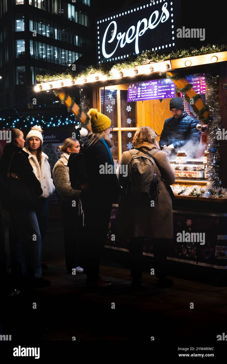 CITY SQUARE, LEEDS, ROYAUME-UNI - 28 NOVEMBRE 2024. Un étal de marché coloré vendant des crêpes aux acheteurs au marché de Noël de Leeds à City Square, Leeds, Banque D'Images