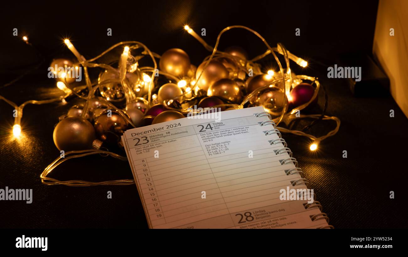 L'almanach suédois s'est déroulé la veille de Noël devant une décoration de boules légères Banque D'Images