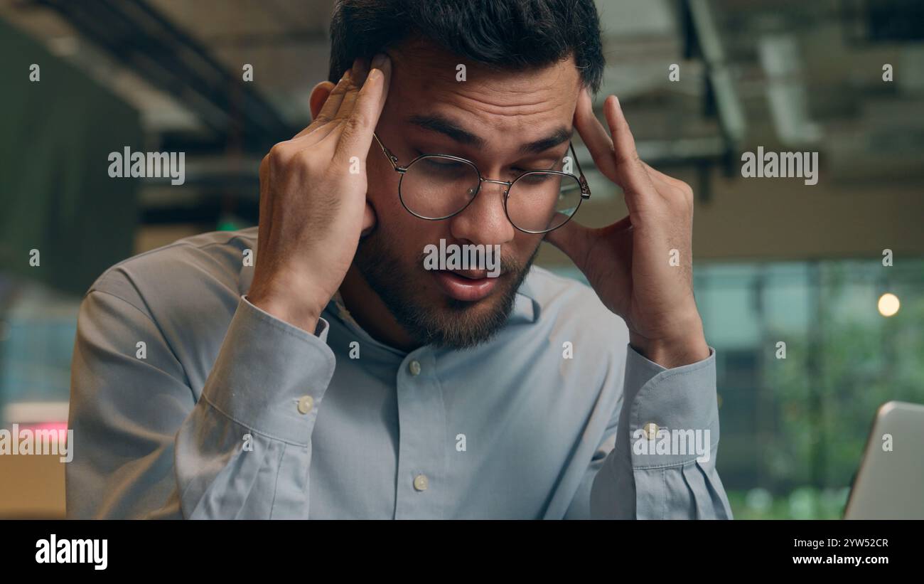 Homme d'affaires bouleversé problème de paperasse Indien Arabique homme d'affaires visiteur dans le café homme triste frustré gars anxieux travail indépendant ordinateur portable fatigué stress Banque D'Images