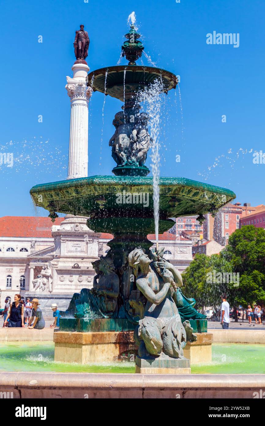 Lisbonne, Portugal - 15 août 2017 : photo de rue verticale, les touristes marchent sur la place Rossio par une journée d'été ensoleillée près de la fontaine du Sud. La colonne o Banque D'Images