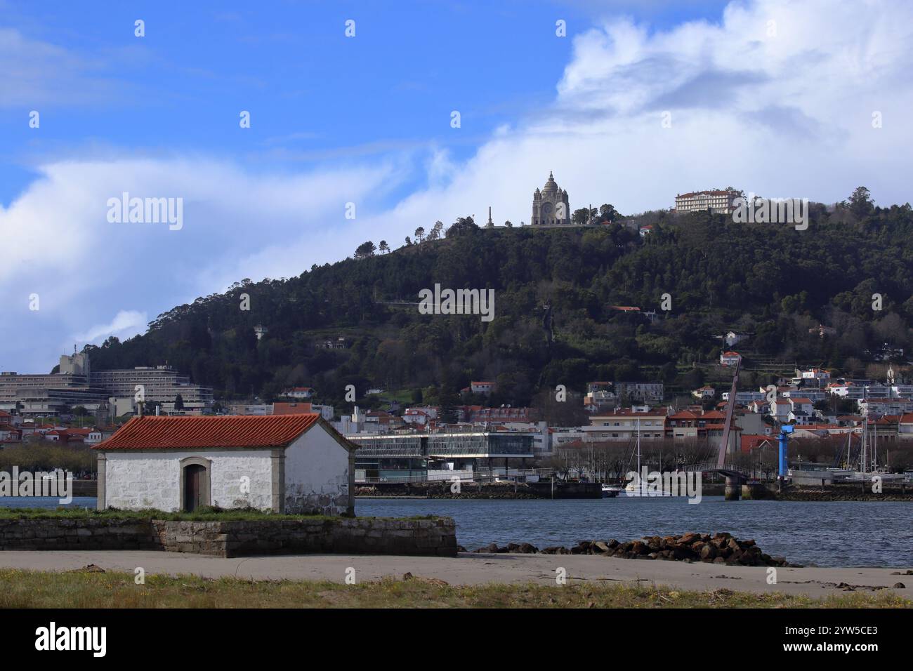 Viana do Castelo, Portugal - 2 mars 2024 : vue panoramique sur le sanctuaire de Santa Luzia au sommet d'une colline boisée avec la rivière Lima et une construction pittoresque au bord de la rivière Banque D'Images Viana do Castelo, Portugal - 2 mars 2024 : vue panoramique sur le sanctuaire de Santa Luzia au sommet d'une colline boisée avec la rivière Lima et une construction pittoresque au bord de la rivière Banque D'Images